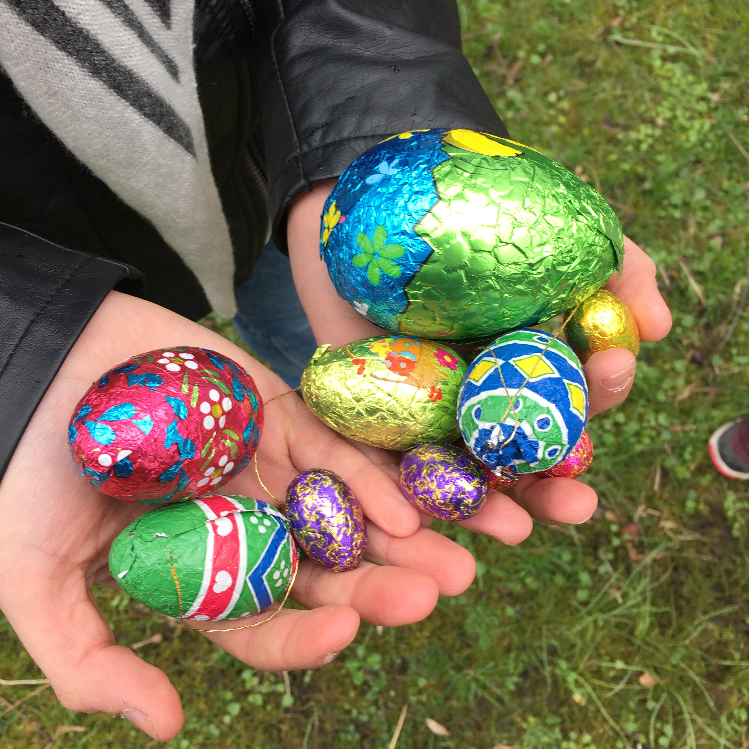 Et par barnehænder fulde af chokoladepåskeæg