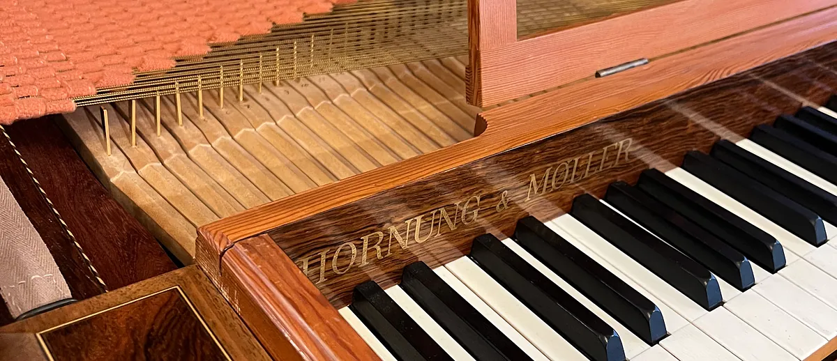 Tastatur og strenge på et rødt clavichord